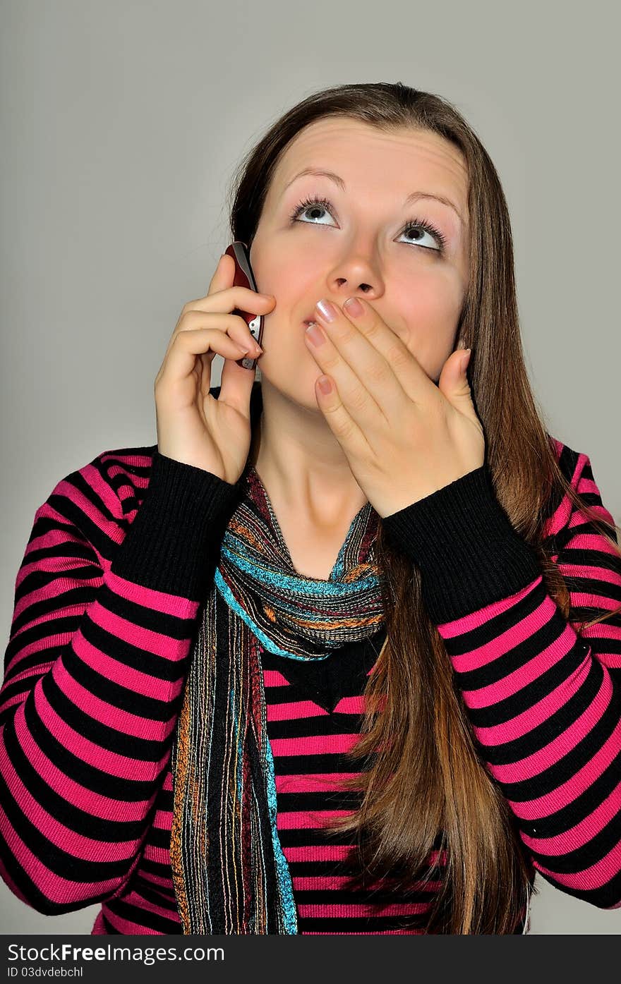 A young girl emotionally expressive talking on a mobile phone. A young girl emotionally expressive talking on a mobile phone