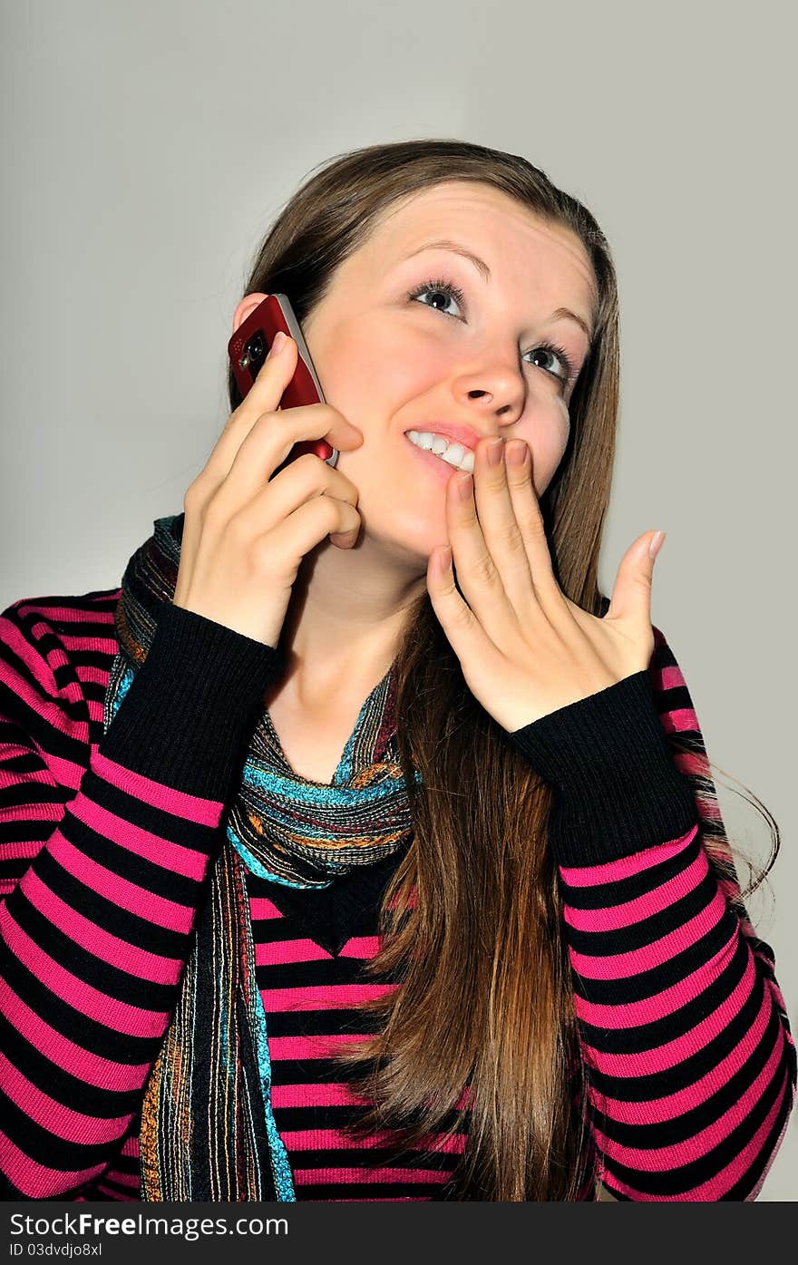 A young girl emotionally expressive talking on a mobile phone. A young girl emotionally expressive talking on a mobile phone