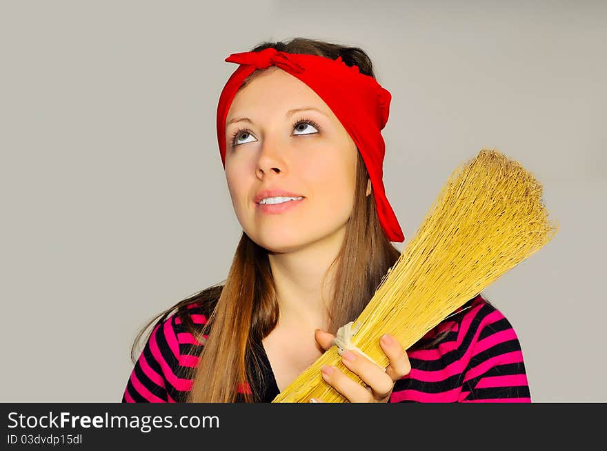 A girl holding a broom and looks up at the ceiling in the apartment. A girl holding a broom and looks up at the ceiling in the apartment