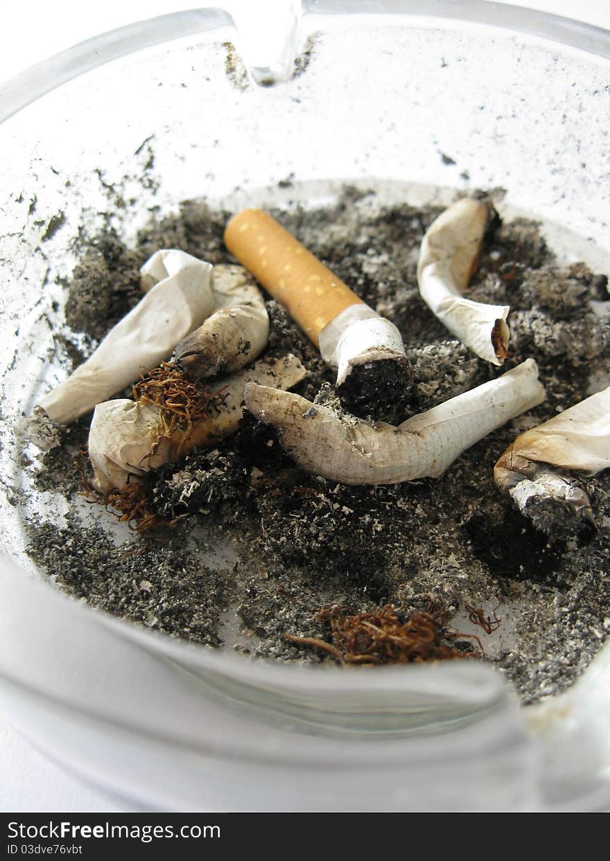 A dirty ashtray full of cigarette ends. A dirty ashtray full of cigarette ends.