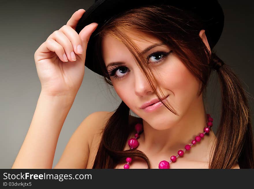 The young woman in a black dress posing in studio. The young woman in a black dress posing in studio