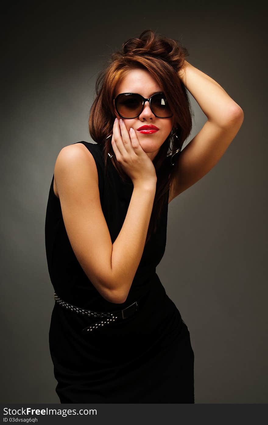 Brunette woman in black dress and glasses