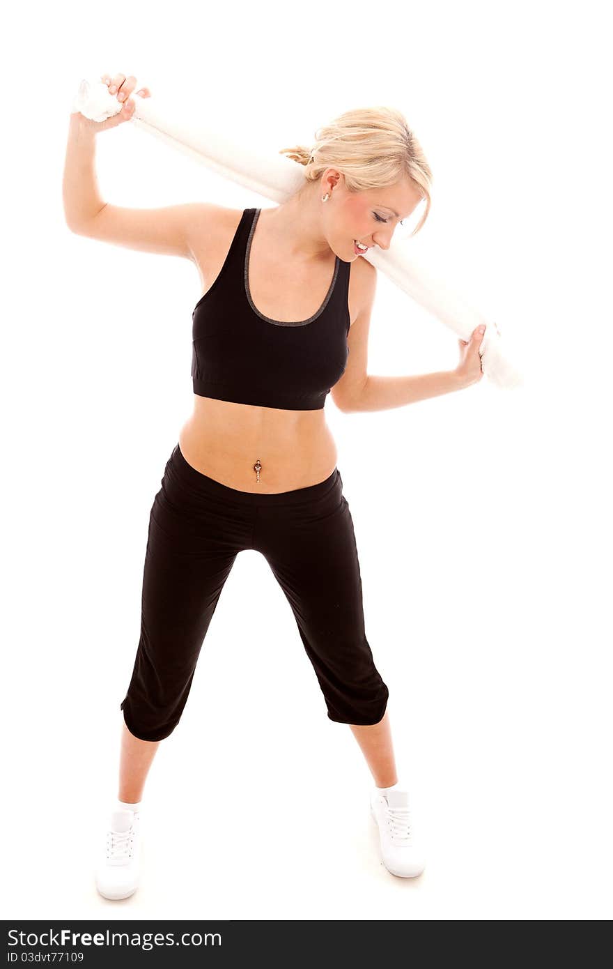 A young female dressed in black gym clothes holding a white towel. A young female dressed in black gym clothes holding a white towel