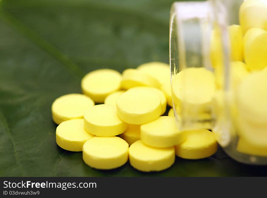 Yellow pill over a green leaf