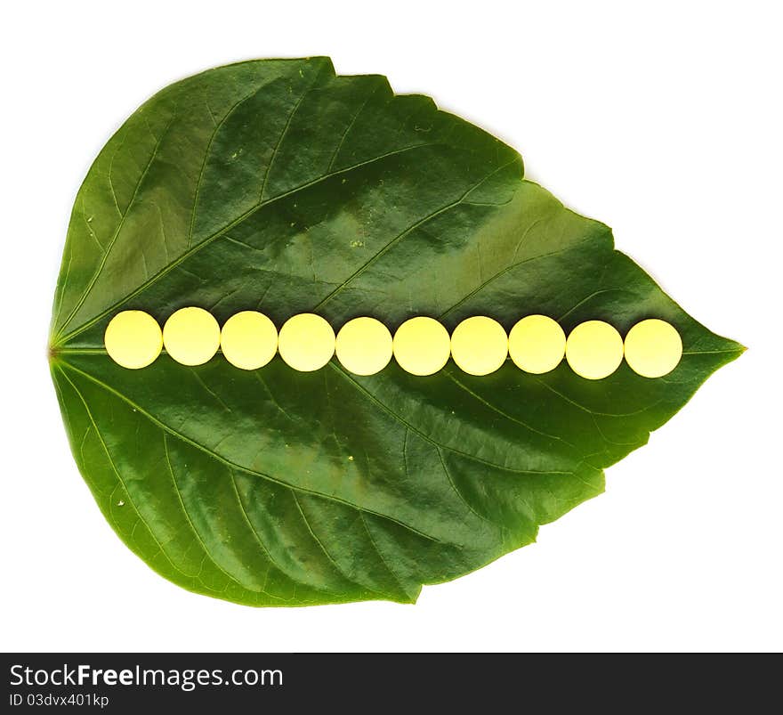 Yellow pill over a green leaf