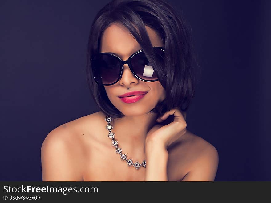 brunette elegant woman wearing sunglasses and neckles. brunette elegant woman wearing sunglasses and neckles