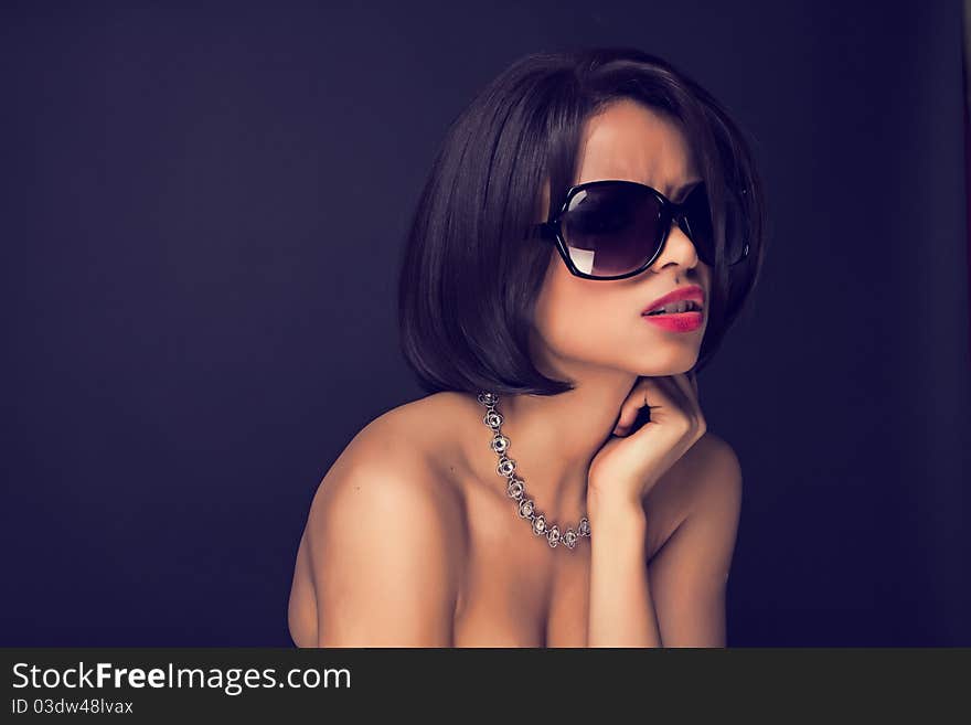 Sexy brunette elegant woman wearing sunglasses and neckles