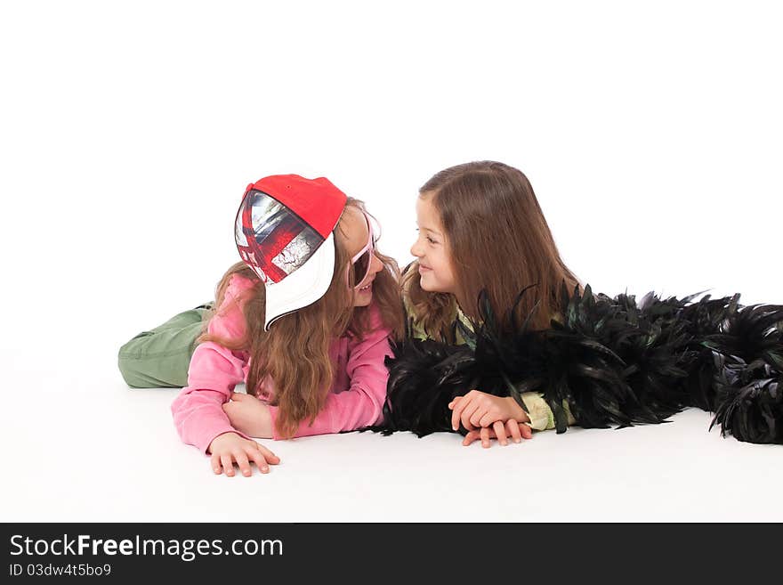 Two freinds looking and smiling and lying isolated with cap and feather boa