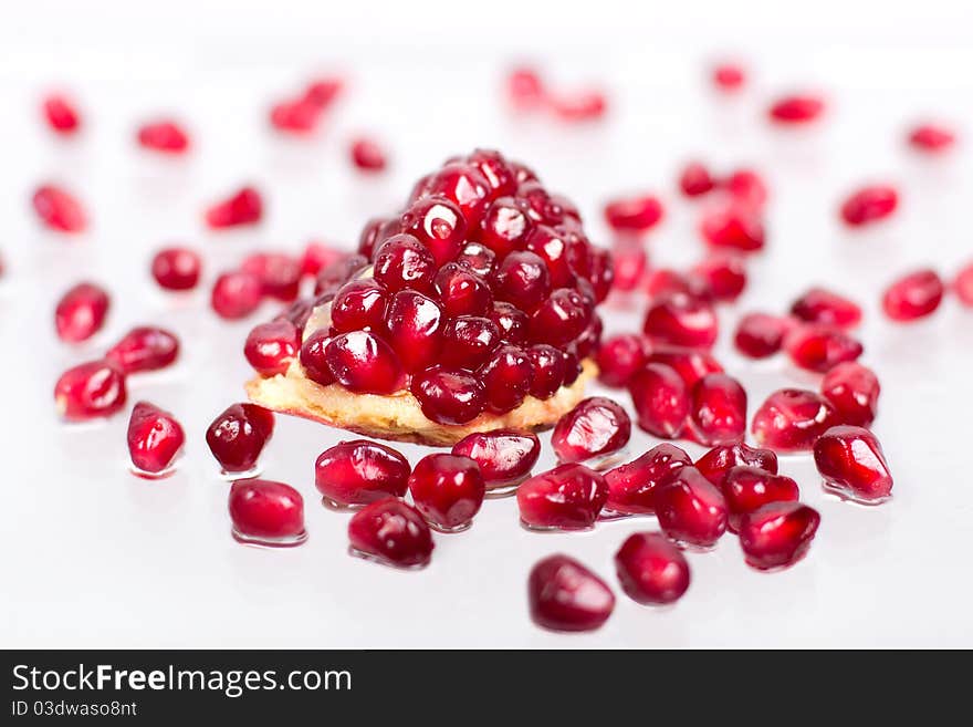 Part of pomegranate with seeds on the white