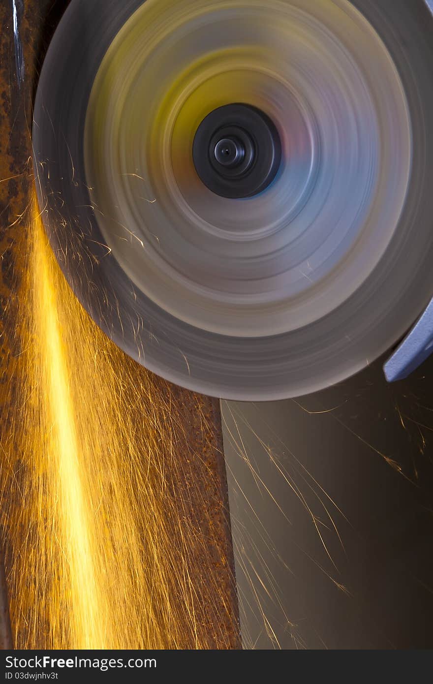 A man working with grinder, close up on tool, hands and sparks, real situation picture