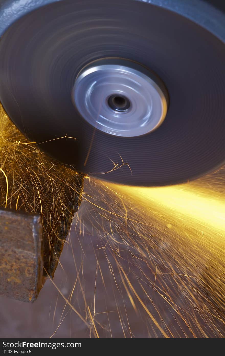 A man working with grinder, close up on tool, sparks fly, real situation picture