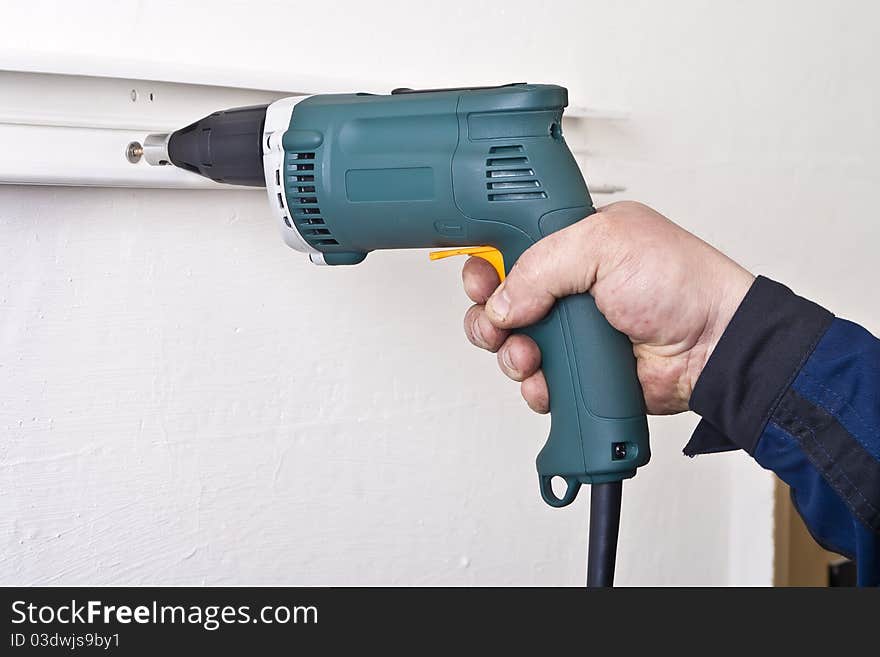 Construction worker using electric screwdriver