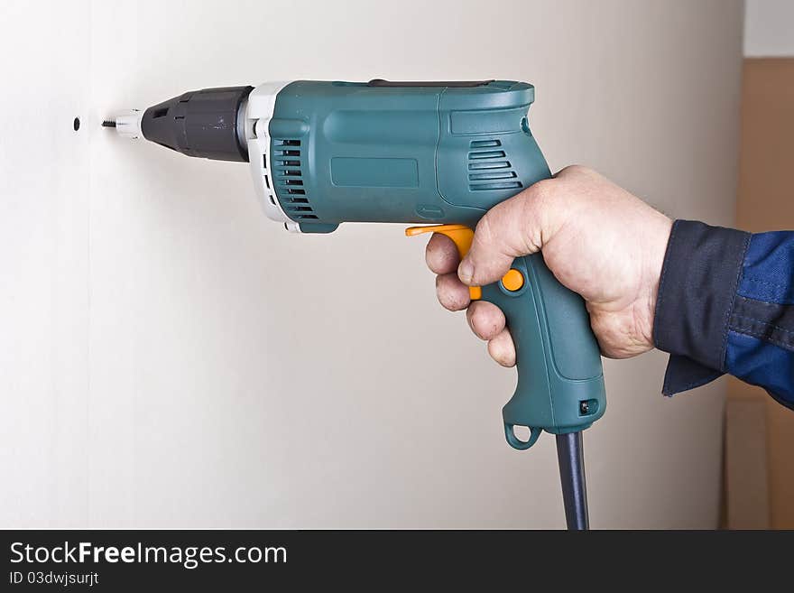 Construction worker using electric screwdriver