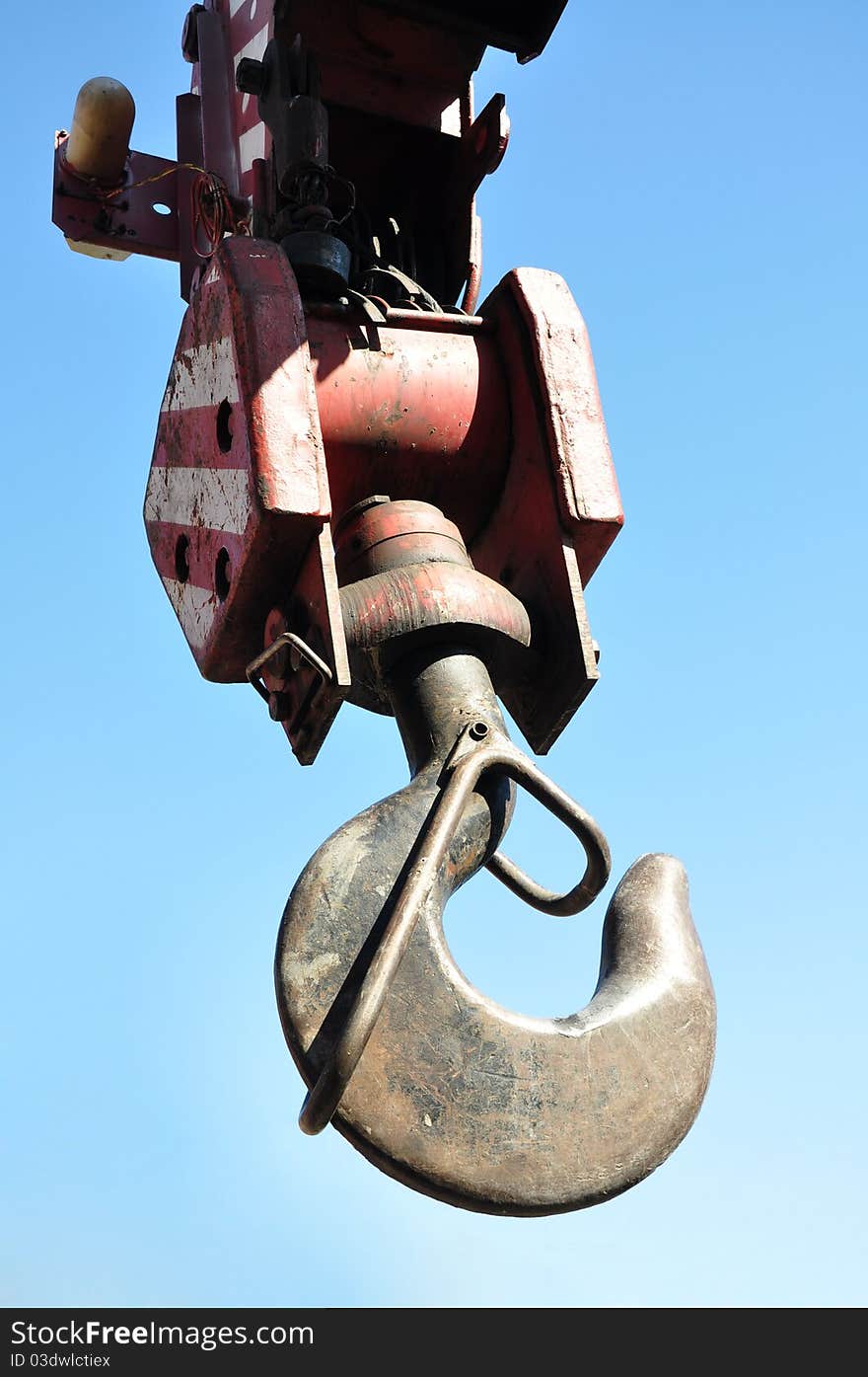 Metal hook of the crane. Against the sky.