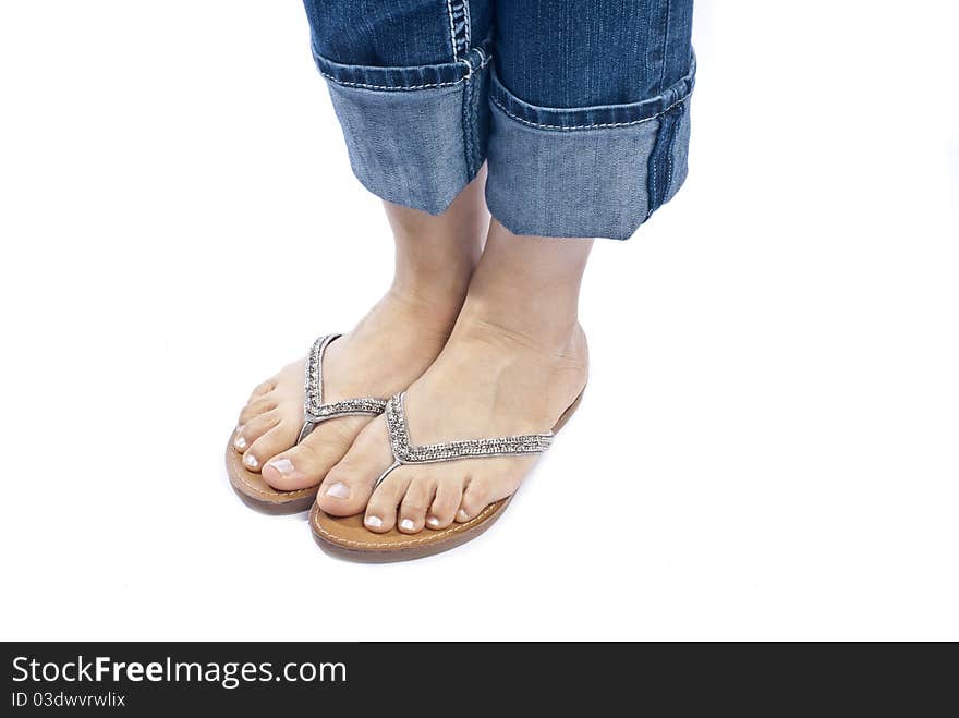 Woman wearing capri blue jeans and a pair of stylish flip flops isolated on white. Woman wearing capri blue jeans and a pair of stylish flip flops isolated on white.