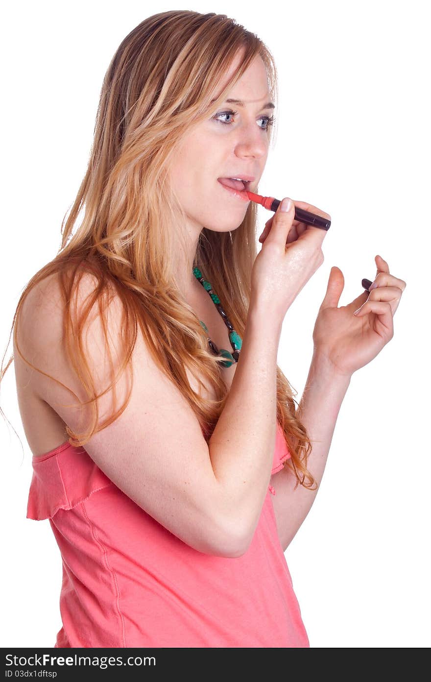 A girl is applying chapstick.  She is in a very colorful outfit. A girl is applying chapstick.  She is in a very colorful outfit.