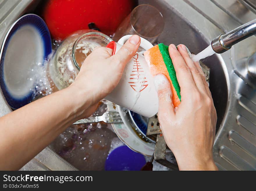 The woman washes ware on kitchen