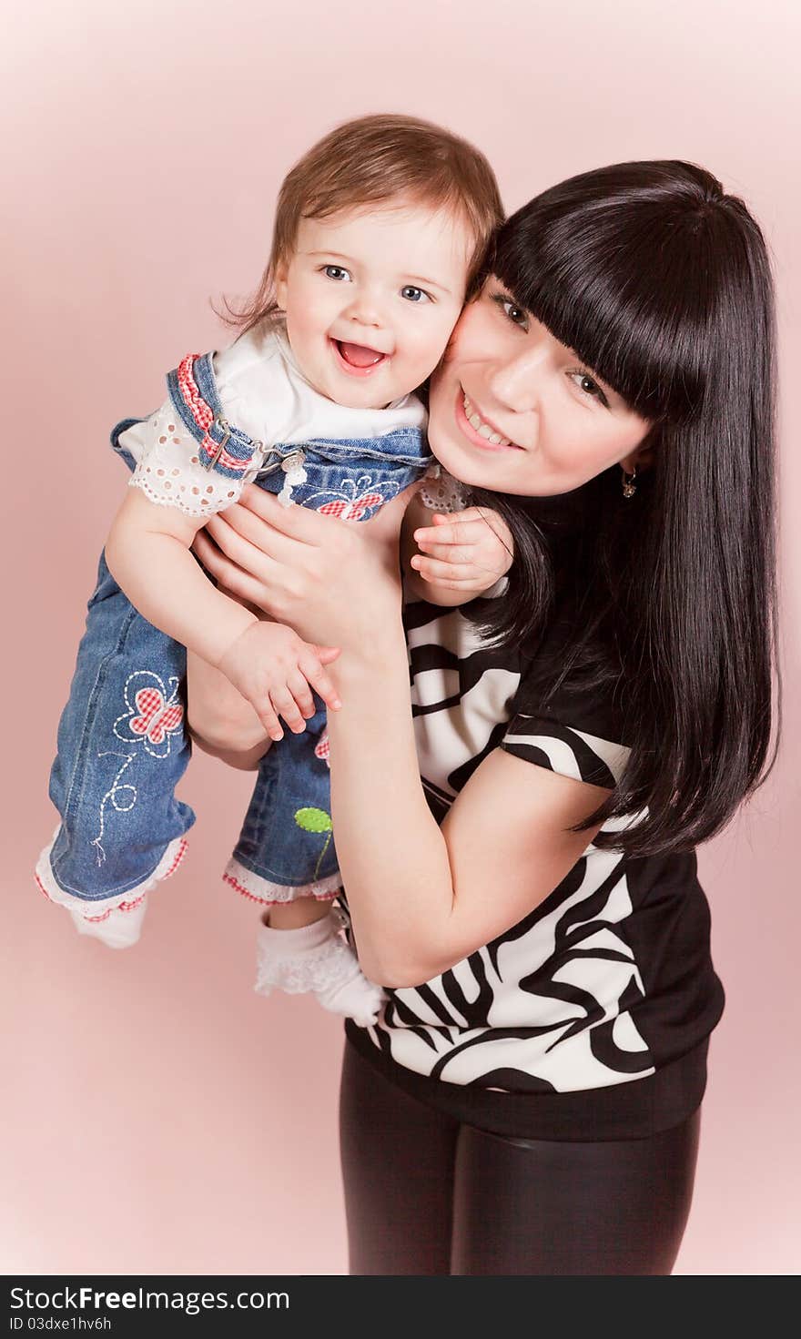 Stock Photo: Happy joyful mother with laughing little daughte in studio