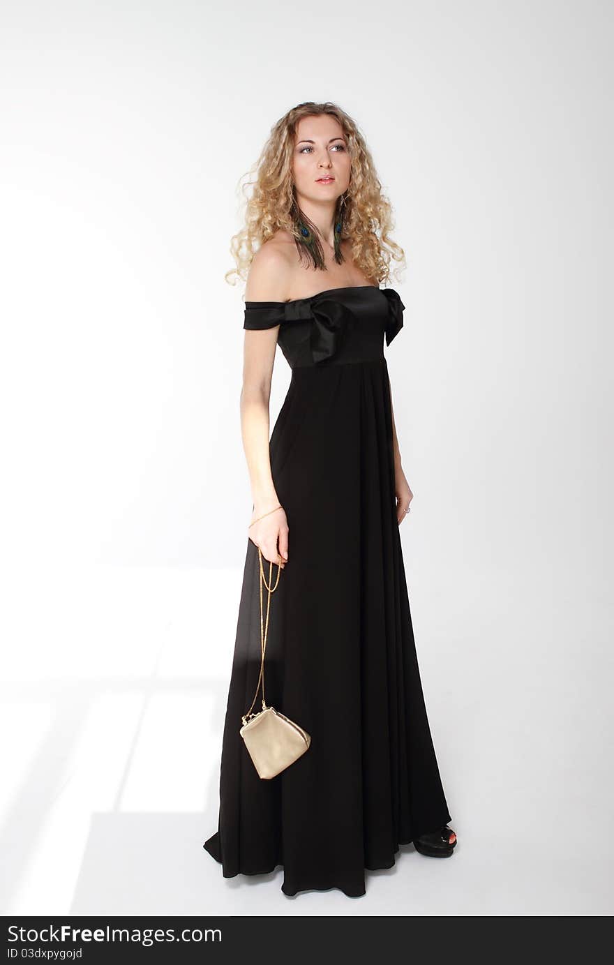 Beauty young blond girl with curly hair in long black dress