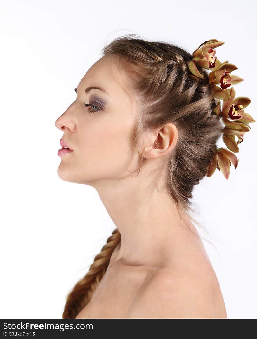 Portrait of the beautiful young blond girl with orchid in her hair