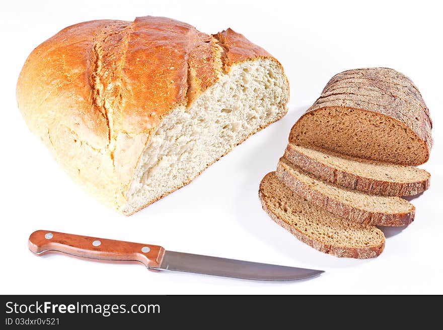 Half of a big white bread loaf and sliced loaf of rye bread with knife isolated on white background. Half of a big white bread loaf and sliced loaf of rye bread with knife isolated on white background