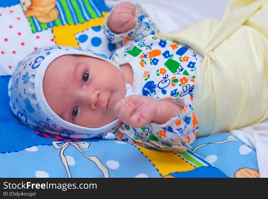 Photo of the beautiful baby lying on bed. Photo of the beautiful baby lying on bed