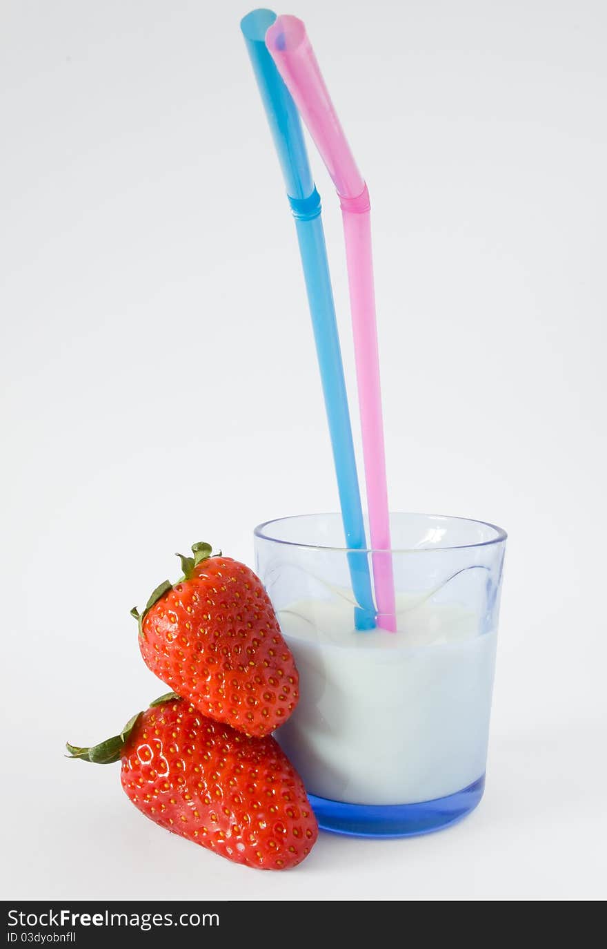 Glass of milk with straw and two strawberries. Glass of milk with straw and two strawberries