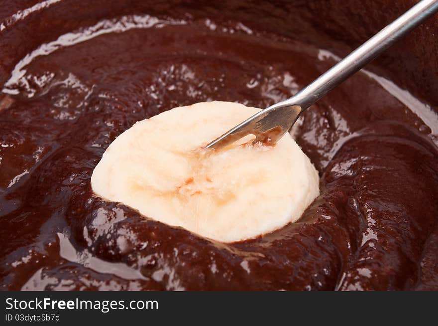 Delicious chocolate fondue with banana macro background