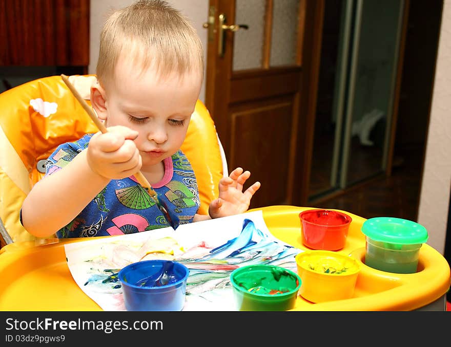 Little boy draws a colorful paints and brushes. Little boy draws a colorful paints and brushes