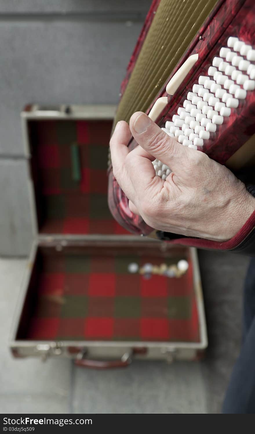 Street performer playing music on a vintage accordion squeeze box. Street performer playing music on a vintage accordion squeeze box