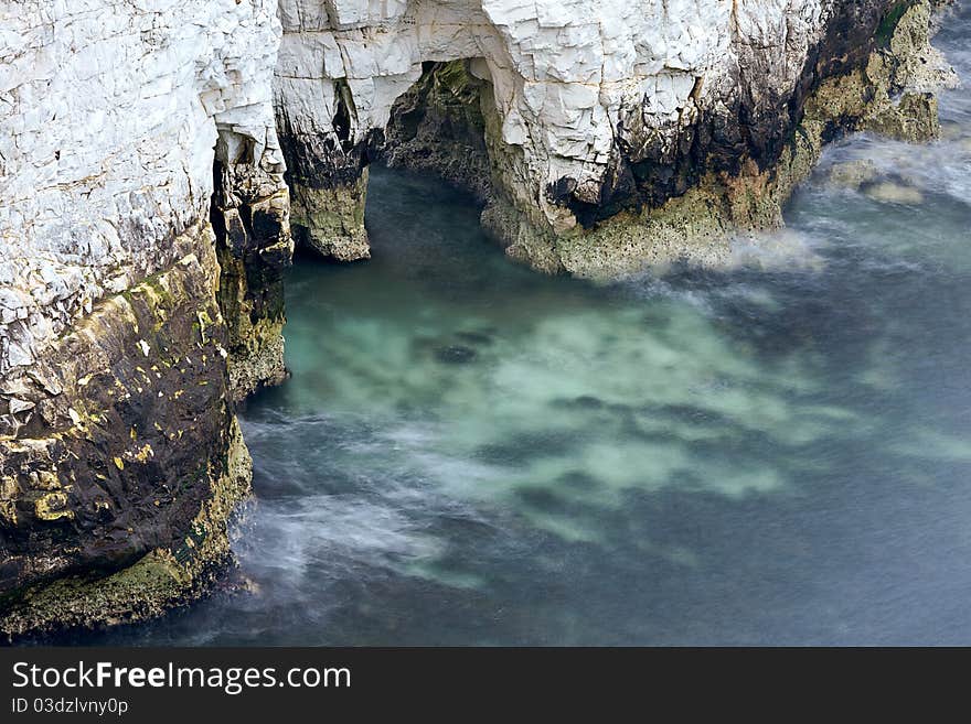 A long exposure of the sea around the bottom of a chalk cliff. Taken in the Jurassic Coast of Dorset. A long exposure of the sea around the bottom of a chalk cliff. Taken in the Jurassic Coast of Dorset.