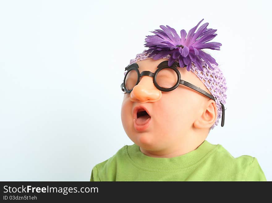 Funny baby wearing toy glasses and headband