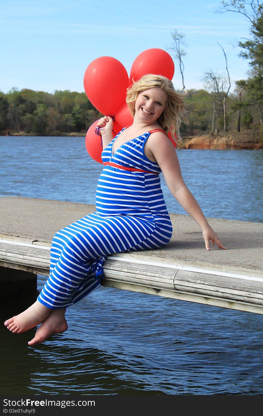 Beautiful pregnant woman on a wooden dock. Beautiful pregnant woman on a wooden dock.