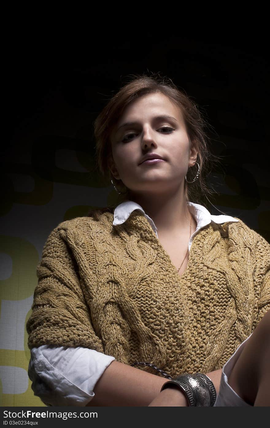 Beautiful young girl on knitted sweater in colorful background