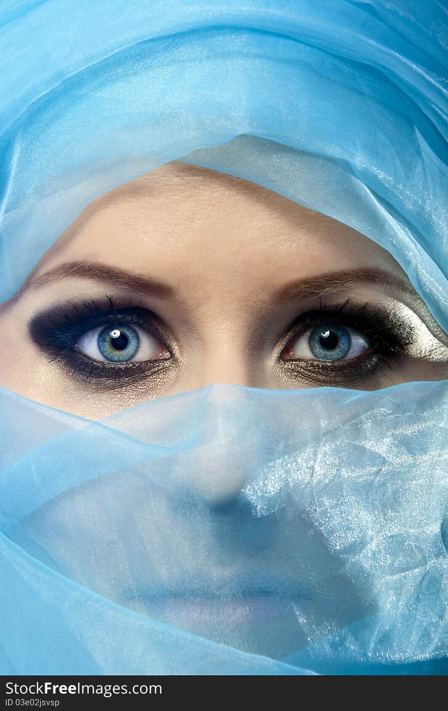 Portrait of a beautiful young girl in a blue veil with beautiful eyes