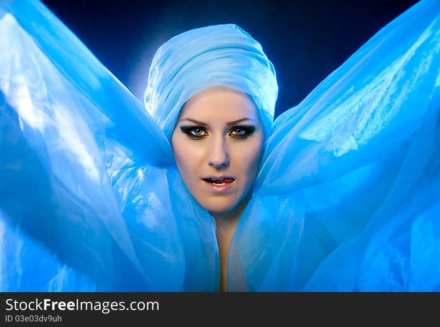 Portrait of a beautiful young girl in a blue veil with beautiful eyes