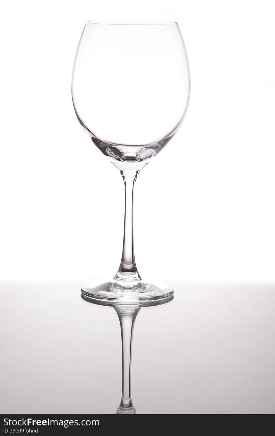 Empty wine glass with mirror reflection