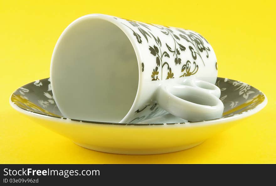 Cup and saucer isolated over yellow background. Cup and saucer isolated over yellow background