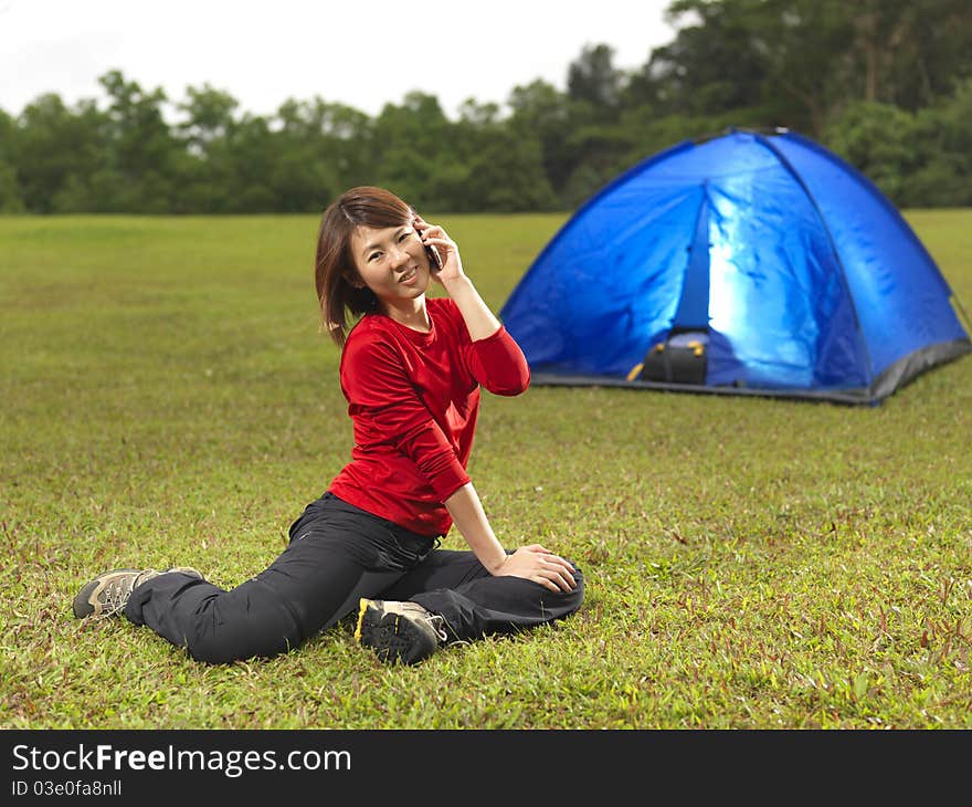 Asian chinese camper using phone to connect to the outside world.