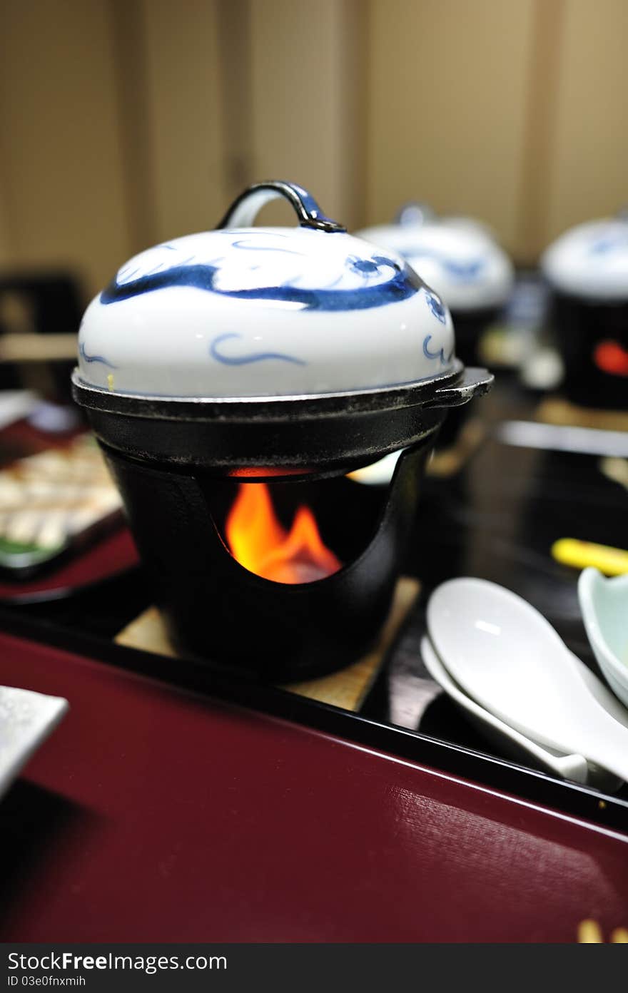 Japanese mini hotpot onto a small stove with fire. Japanese mini hotpot onto a small stove with fire