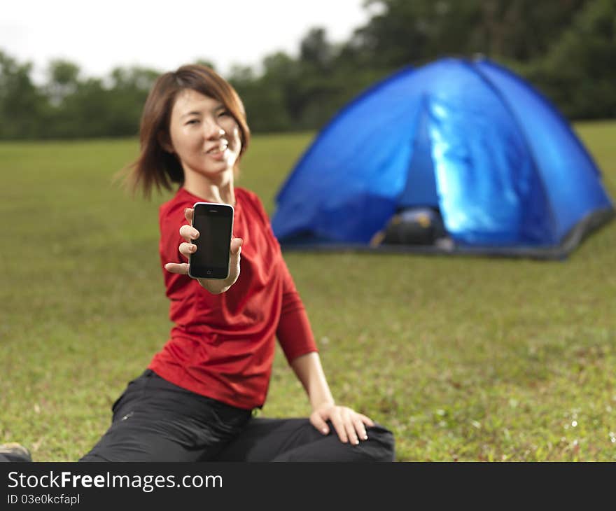 Asian female camper showing her mobile phone