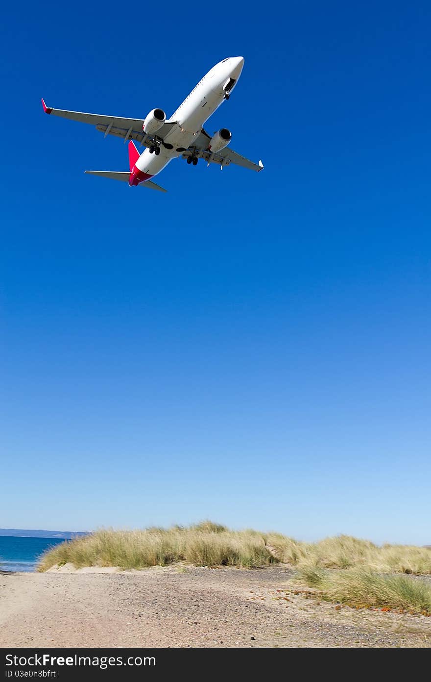 Low airplane coming in to land over Seven Mile Beach, Tasmania.