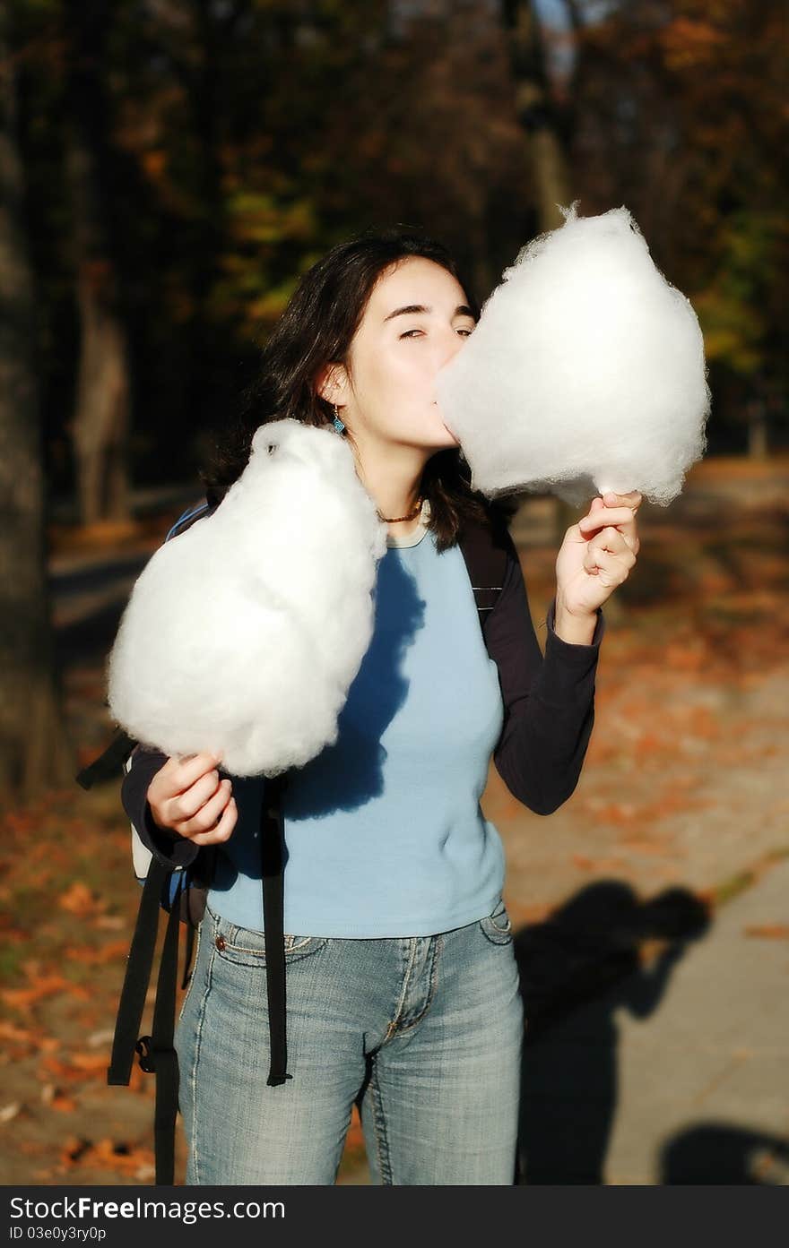 Girl eating cotton candy in the park