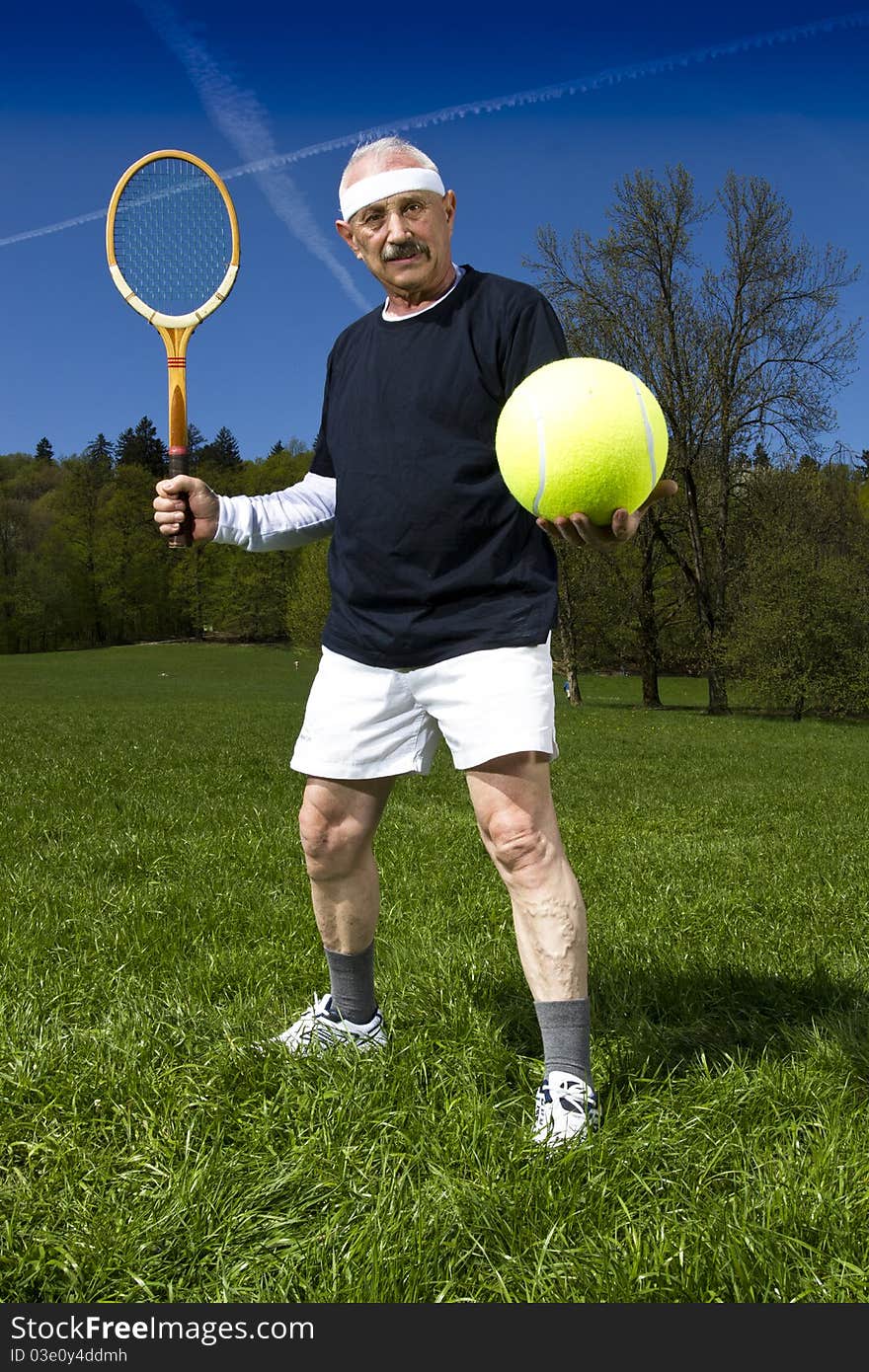 Senior man playing tennis with retro racquet