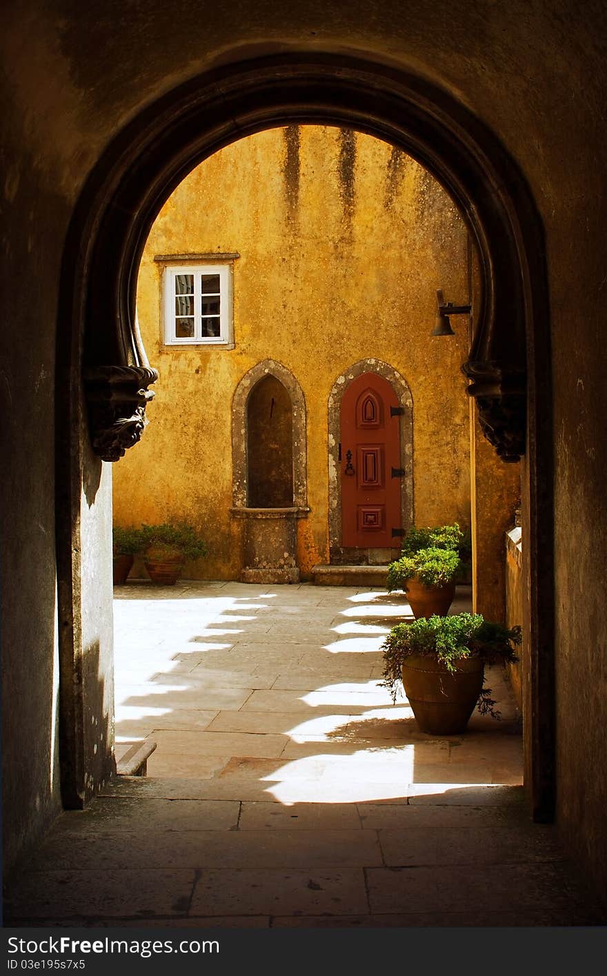 View of a courtyard of the palace of the penalty through a stone arch. View of a courtyard of the palace of the penalty through a stone arch