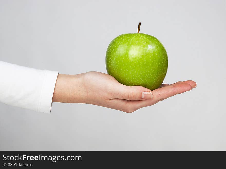 Green healthy apple in woman hand isolated on white background. Green healthy apple in woman hand isolated on white background