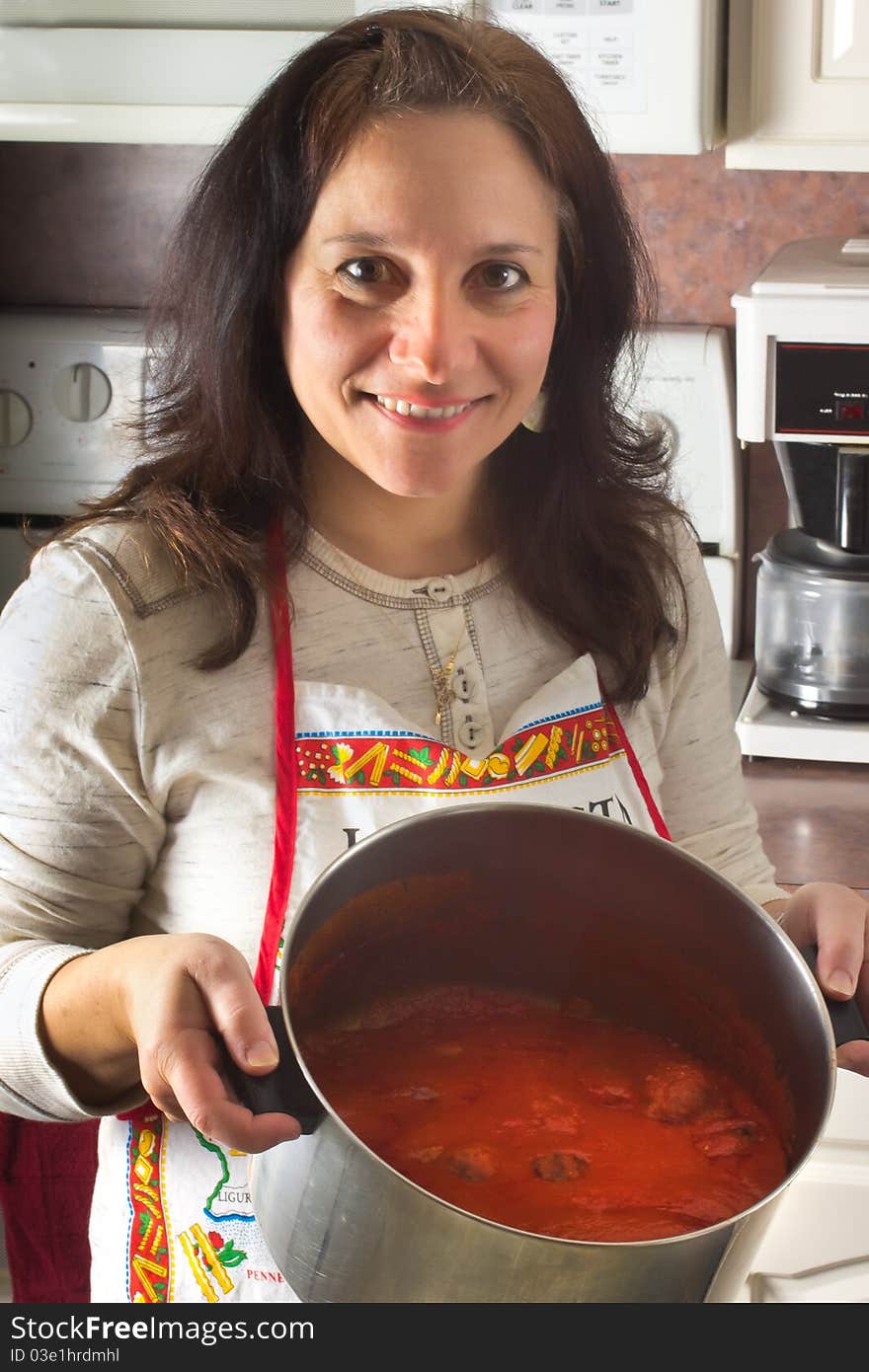 An woman displays the her pot of Italian style sauce and meatballs; a Sunday tradition. An woman displays the her pot of Italian style sauce and meatballs; a Sunday tradition.