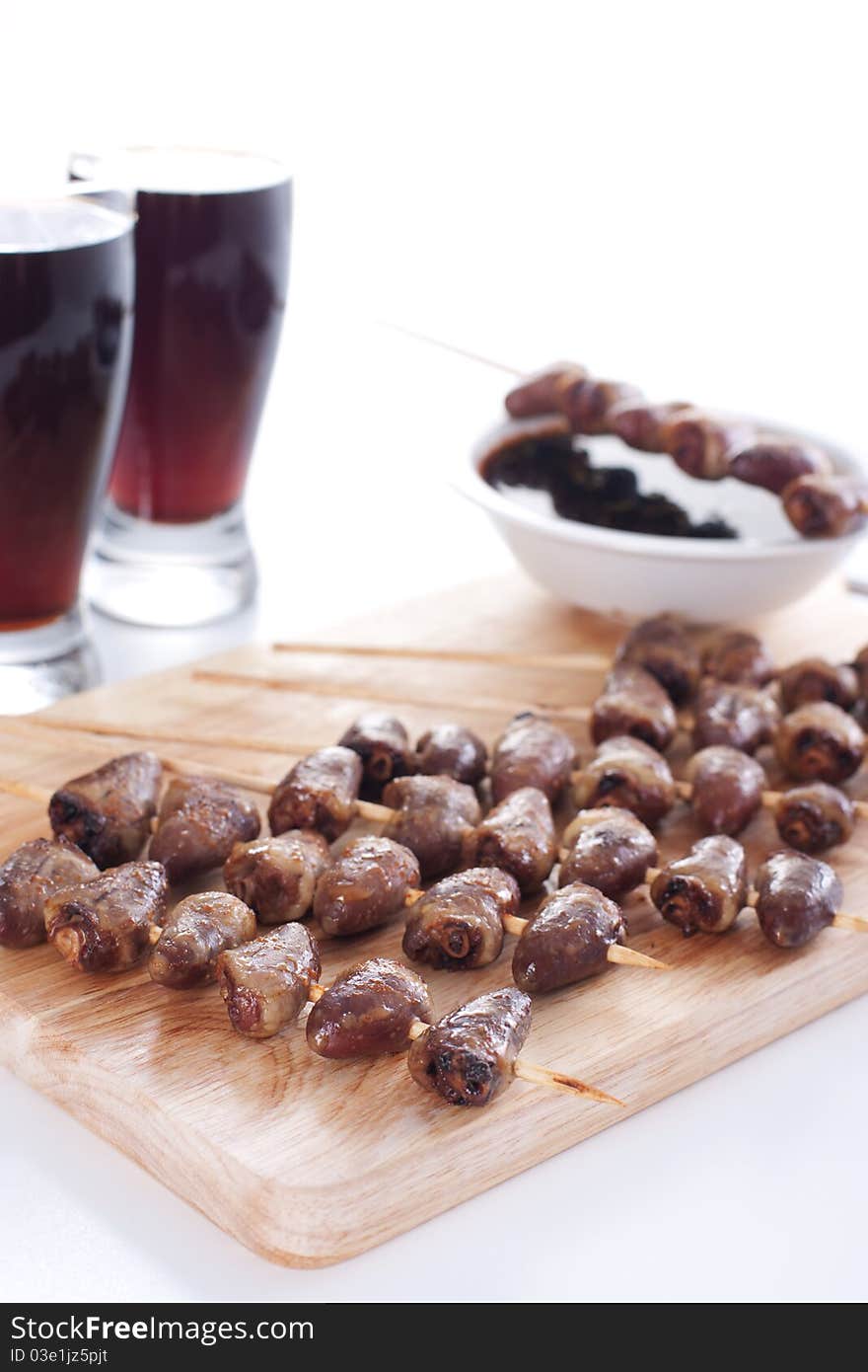 Grilled chicken hearts on skewers with soy sauce, salad and beer