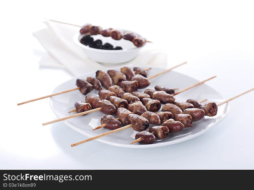 Grilled chicken hearts on skewers with soy sauce and salad.