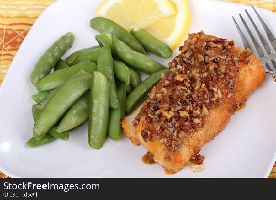 Fried cod fish fillet with snap peas and lemon slice. Fried cod fish fillet with snap peas and lemon slice